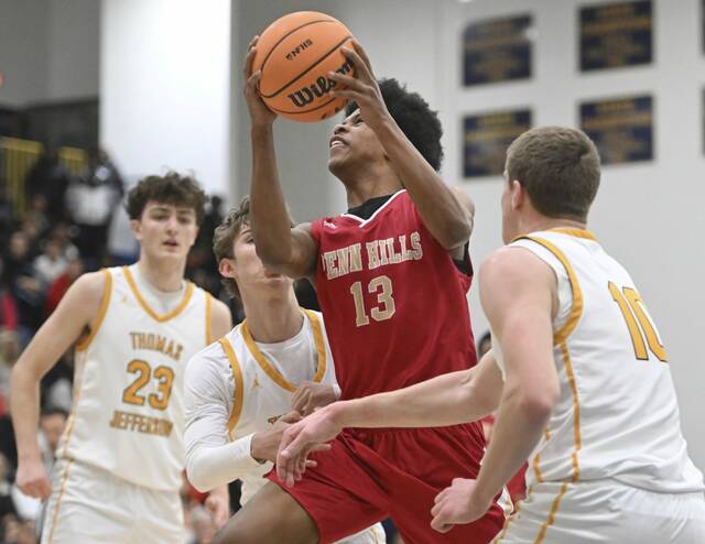 Penn Hills Darian Robinson scores past Thomas Jeffersons Noah Sear and Justin Fry during WPIAL Class 5A playoff action Friday, Feb. 20, 2026 at Norwin High School. (Chaz Palla | TribLive)
