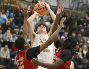 Thomas Jeffersons Nicholas Trklja elevates over Penn Hills Tyrone Johnson and Dallas Smith during WPIAL Class 5A playoff action Friday, Feb. 20, 2026 at Norwin High School. (Chaz Palla | TribLive)