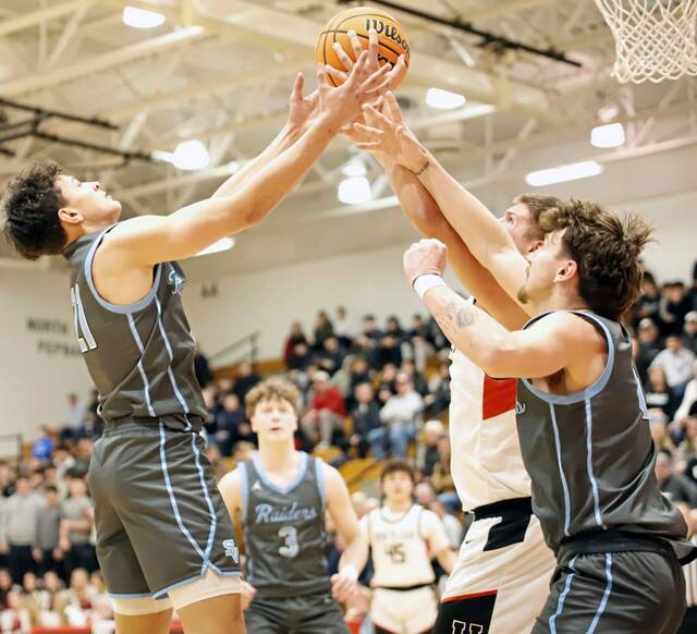 Seneca Valleys Mason McMahan, left, attempts to snatch a rebound away from Upper St. Clairs Ryan Robbins as Raiders teammate Jaxon Householder, right, comes to support him during a WPIAL Class 6A semifinal Monday, Feb. 23, 2026 at North Hills Middle School. (Josh Rizzo | For TribLive)