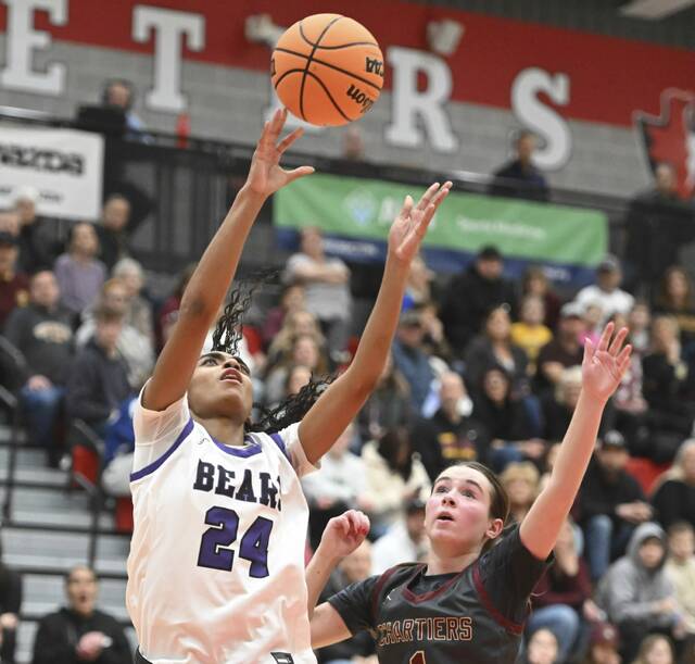 Winchester Thurstons DaShae Cochran scores over Chartiers-Houstons Mackenzie Walsh during the WPIAL Class 2A semifinals Tuesday. (Chaz Palla | TribLive)