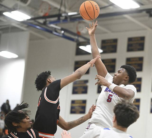 Jeannettes Markus McGowan scores over Clairtons Jaece Booker during a WPIAL Class 2A semifinal at Norwin High School. (Chaz Palla | TribLive)