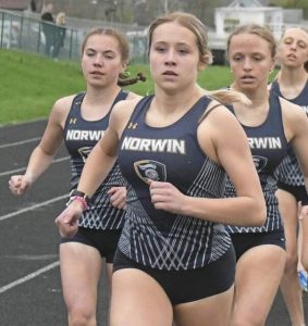 Norwins Annie Czajkowski leads teammates Addie Farrah (left) and Anna Dansak (right) during the 1,600-meter run on April 4, 2025. (Paul Schofield | TribLive)