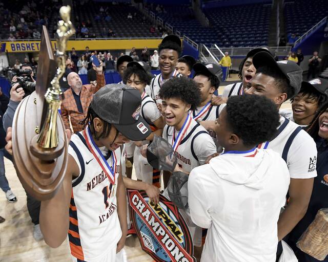 The Neighborhood Academy’s Kedron Gilmore hoists the WPIAL championship trophy with his teammates after defeating Serra Catholic in the Class A final on Thursday, Feb. 26, 2026, at Petersen Events Center. (Christopher Horner | TribLive)