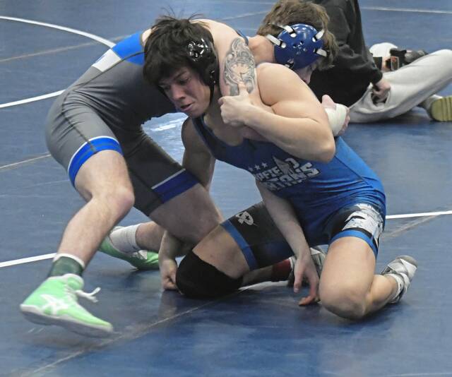 Hempfield senior Nate Caracciolo looks to take down Connellsville junior Nolan Rice during the PIAA Class 3A West Regionals on Friday. (Paul Schofield | TribLive)