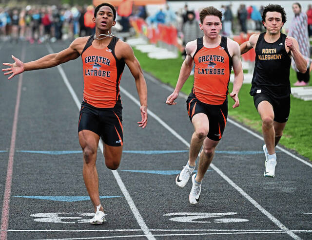 Latrobes Preston Miller wins the 100 meters in meet record time ahead of Adam Piper and North Alleghenys Rocco Martino during the Spartan Lady Wildcat Invitational on April 11, 2025 at Memorial Stadium. (Chaz Palla | TribLive)