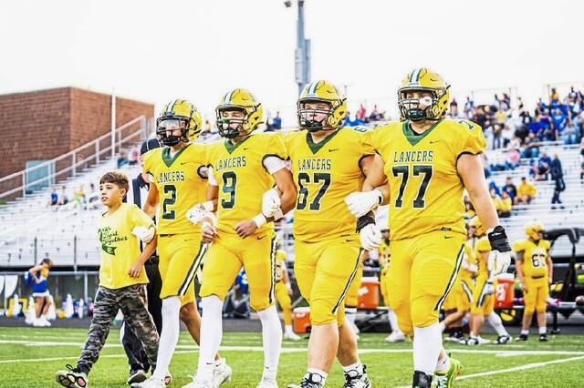 Marco Mangieri, at left, with brothers Luca and Dante Mangieri and fellow captains Joey Ashi and Shaun Bier, take the field for the coin toss before Deer Lakes game with Derry on Sept. 5, 2025, at Lancers Stadium. (Submitted | Erica Mangieri)