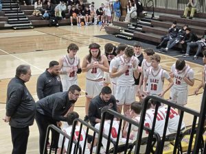 Ligonier Valley coach Dante Porter (kneeling) leads a huddle with his players during a game at the Greensburg Salem Holiday Classic. (Bill Beckner Jr. | TribLive)