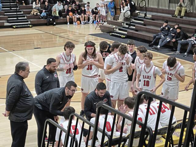 Ligonier Valley coach Dante Porter (kneeling) leads a huddle with his players during a game at the Greensburg Salem Holiday Classic. (Bill Beckner Jr. | TribLive)