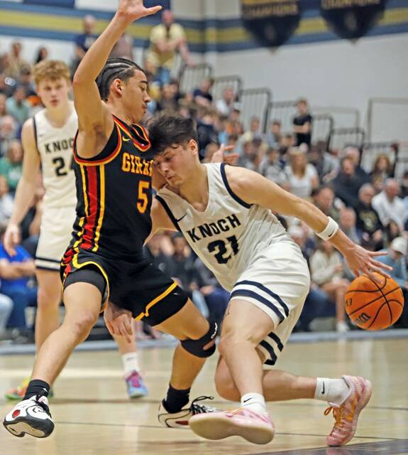 Knoch's Teegan Finucan attempts to dribble behind his back to create space to get past Girard's Kenny Godoy on Friday night at Knoch High School during the PIAA Class 4A playoffs. (Josh Rizzo | For TribLive)