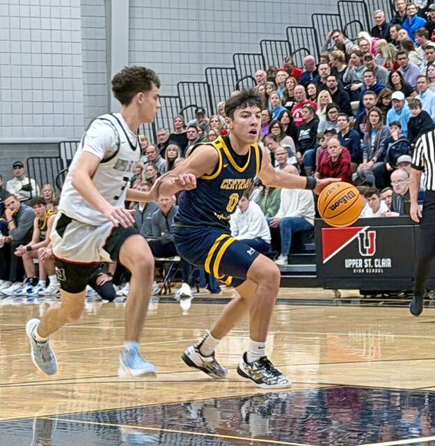 Central Catholics June Ausi drives as Upper St. Clairs Jake Foster defends Jan. 16. (Antonio Rossetti | For TribLive)
