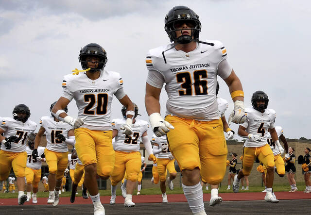 Thomas Jefferson‚s Deacon Kamberis (36) and Jarrett Becoate (20) take the field with their teammates before their game on Friday, Sept. 5, 2025, at McKeesport. (Christopher Horner | TribLive)