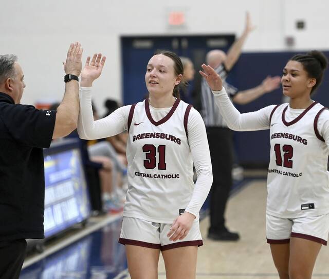 Greensburg Central’s Avery Jones and Jayla Peterson celebrates with head coach Chris Skatell, as they exit the game late in the fourth quarter of their PIAA Class 3A state semifinal against Shady Side Academy on Monday, Mar. 16, 2026, at Norwin. (Christopher Horner | TribLive)