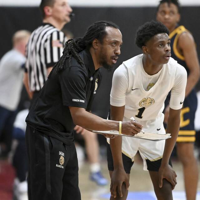 Imani head coach Khayree Wilson talks with R.J. Sledge during a free throw late in the Saints game against Central Catholic on Thursday, Feb. 6, 2025, at CCAC. (Christopher Horner | TribLive)