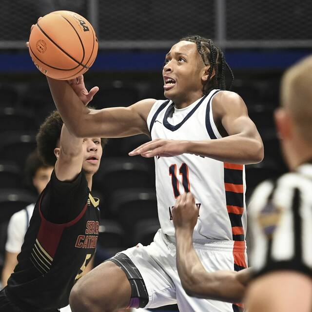 The Neighborhood Academys Kedron Gilmore scores past Serra Catholics Tyler Graham during the WPIAL Class A championship game Feb. 26 at Petersen Events Center. (Christopher Horner | TribLive)