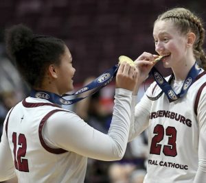 Greensburg Central’s Jayla Peterson and Erica Gribble celebrate with their gold medals after defeating Holy Redeemer in the PIAA Class 3A state championship game on Thursday, Mar. 19, 2026, at Giant Center in Hershey. (Christopher Horner | TribLive)