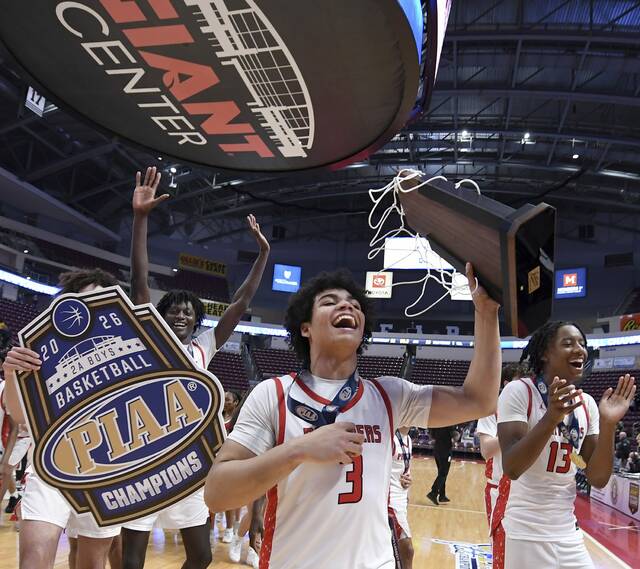 Sewickley Academys Amare Spencer carries the state championship trophy from the court after the Panthers defeated Old Forge in the PIAA Class 2A final on Friday, March 20, 2026, at Giant Center in Hershey. (Christopher Horner | TribLive)