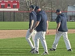 Freeport coach Ed Carr (center) walks to the outfield with his assistant coaches to meet with their players following the Yellowjackets 7-3 victory over Ligonier Valley on Tuesday in Ligonier. (Dave Mackall | For TribLive)