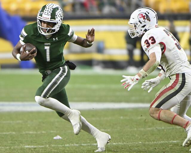 Pine-Richland quarterback Aaron Oobi Strader fends off Peters Townships James Spratt during the WPIAL Class 5A championship game on Saturday, Nov. 22, 2025, at Acrisure Stadium. (Christopher Horner | TribLive)