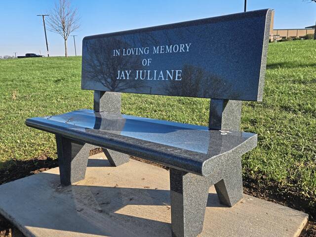 A memorial bench for the late Joseph "Jay" Juliane sits on the hillside above the Penn-Trafford baseball field. (Bill Beckner Jr. | TribLive)