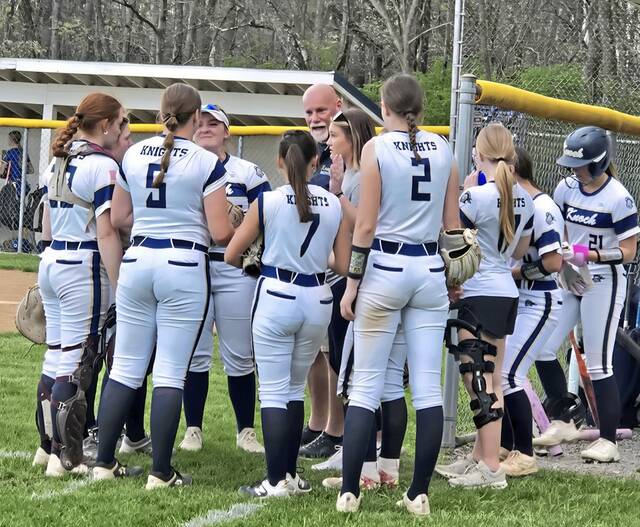 Knoch softball players huddle with coach Chris Gardner (center) during Friday's Section 1-4A game at Derry. (Bill Beckner Jr. | TribLive)