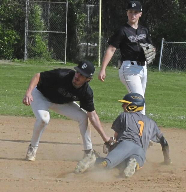 Greensburg Central Catholic second baseman Nick Sopko tags out Carmichaels shortstop Ryder Kreig trying to advance on a wild pitch Wednesday. (Paul Schofield | TribLive)