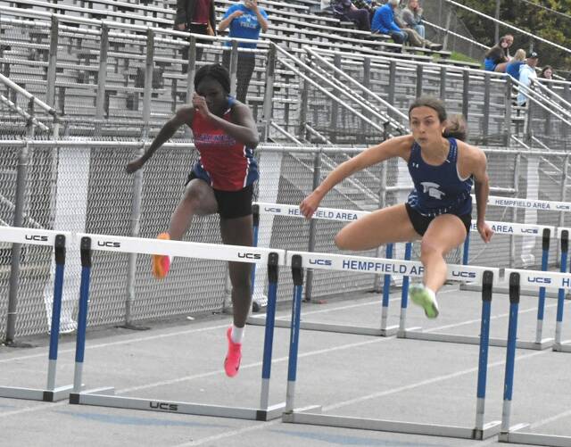 Hempfield junior Angelina Overfield edges Laurel Highlands junior Sahayla Dues in the 100-meter hurdles Tuesday. (Paul Schofield | TribLive)