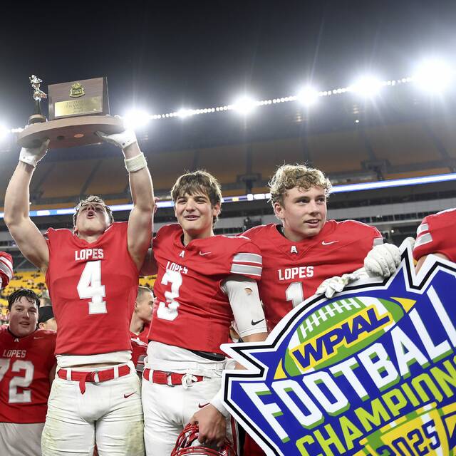 Avonworths Luca Neal hoists the WPIAL championship trophy next to Carson Bellinger and Jackson Krul after defeating Imani Christian in the Class 3A final on Saturday, Nov. 22, 2025, at Acrisure Stadium. (Christopher Horner | TribLive)