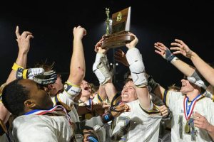 Shady Side Academy's John Poggi (23) hoists the 2026 WPIAL Class 3A championship trophy as he is swarmed by his team after defeating Pine-Richland on Wednesday, May 20, 2026, at Upper St. Clair. (Andrew Palla | For TribLive)