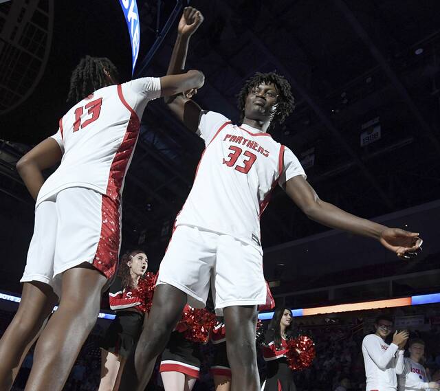Sewickley Academys Adam Ikamba takes the court with JaMere Guyton during player introductions before the PIAA Class 2A state championship game against Old Forge on March 20 at Giant Center in Hershey. (Christopher Horner | TribLive)