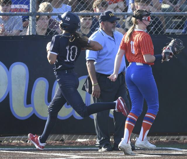 Shalers Olivia Gieraltowski scores on a wild pitch past Armstrongs Josie Porter during their WPIAL Class 5A quarterfinal Tuesday at Plum. (Christopher Horner | TribLive)